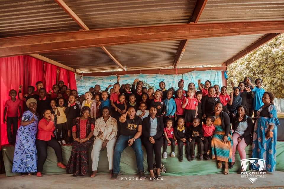 Henrietta Nonye Odey with the Director of Brightlee Defense System, other collaborators, teachers and pupils.