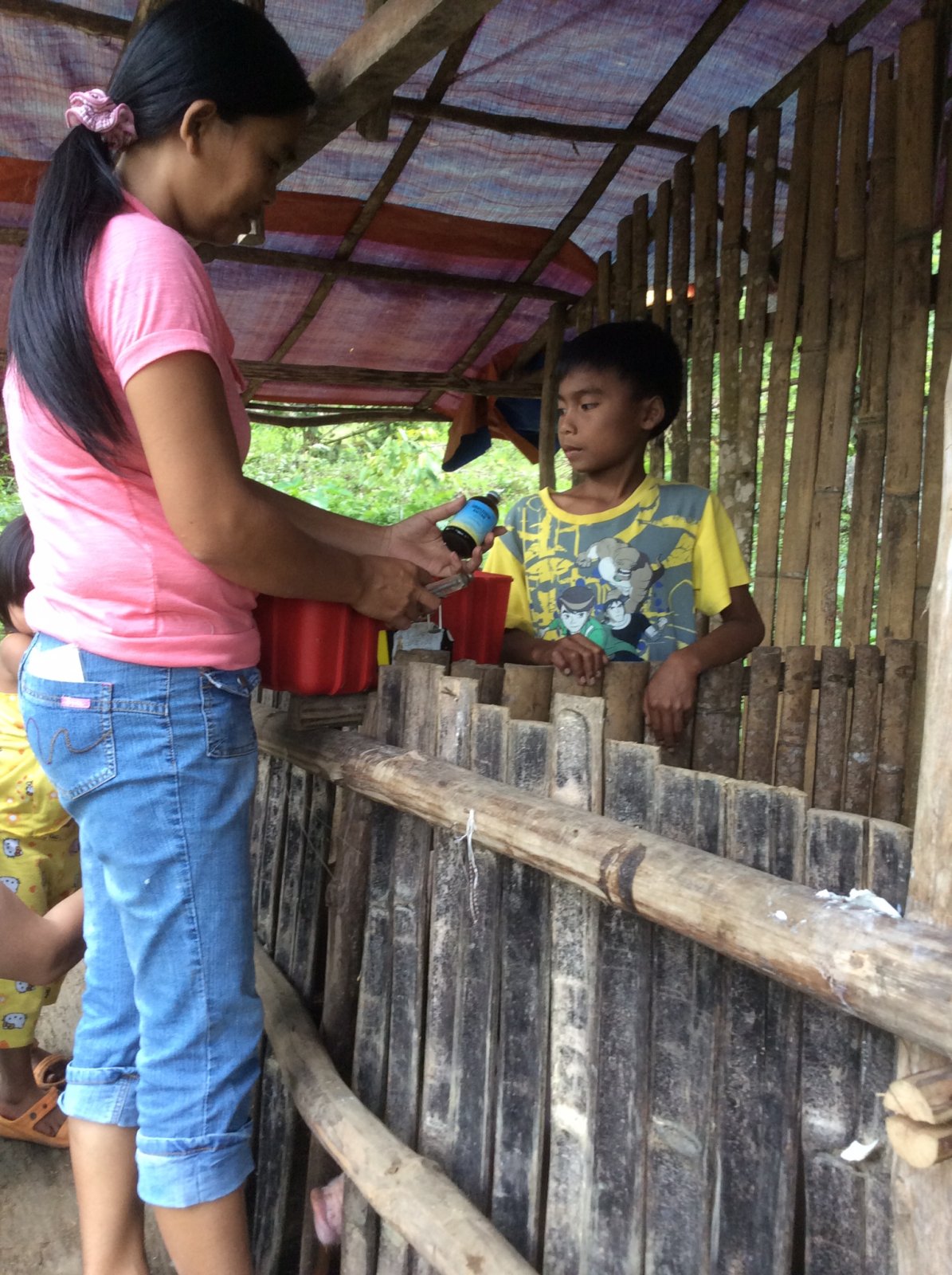 Abeth giving simple instructions to her son on taking care of their pigs.