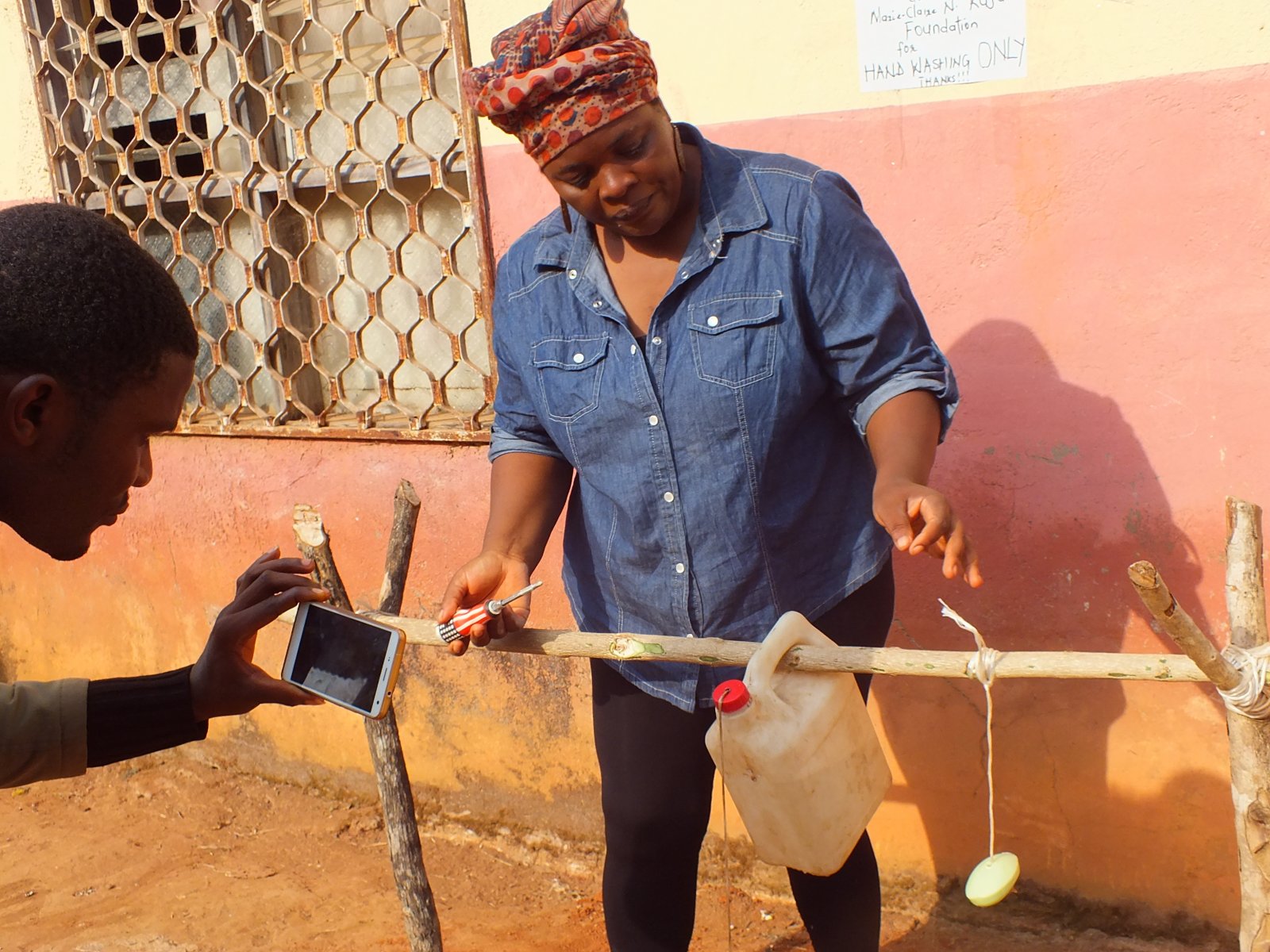 On the hills of  Esu installing a Tippy Tap ( a hand washing device which is installed using local materials) .This  took Esu by storm and Its low tech,low cost and saves lives.