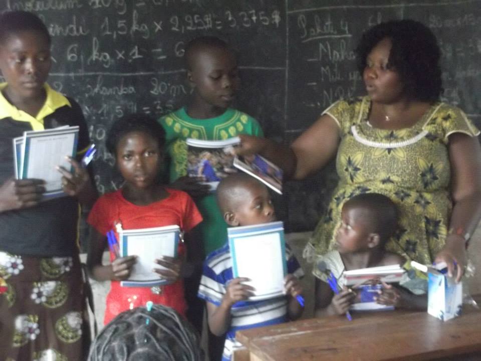 COFAPRI Executive Secretary giving school equipment to children under our education sponsorship.