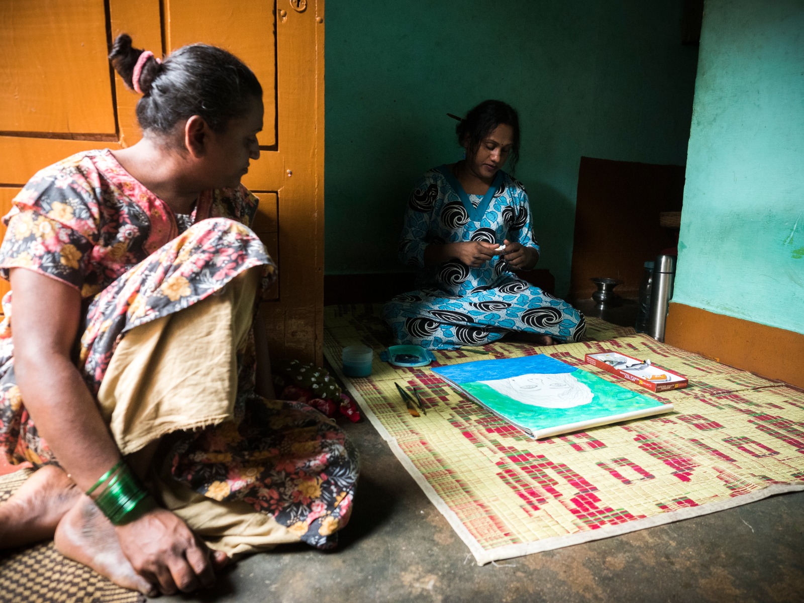 Shanthi seen here painting in her house after SRS with her room-mate who looked after her during and after SRS