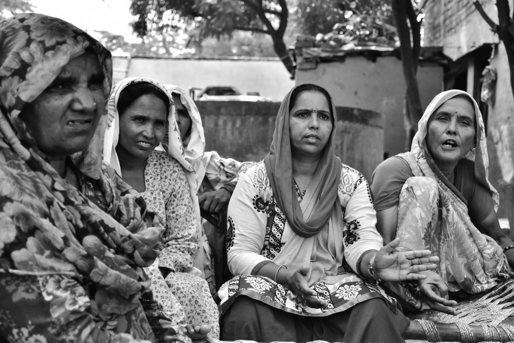 Mewat Radio supervisor and senior reporter Sunita Mishra, center, sits with Hoora Begum, second from left, and other women to discuss issues for Radio Mewat’s next broadcast. (Aliya Bashir)