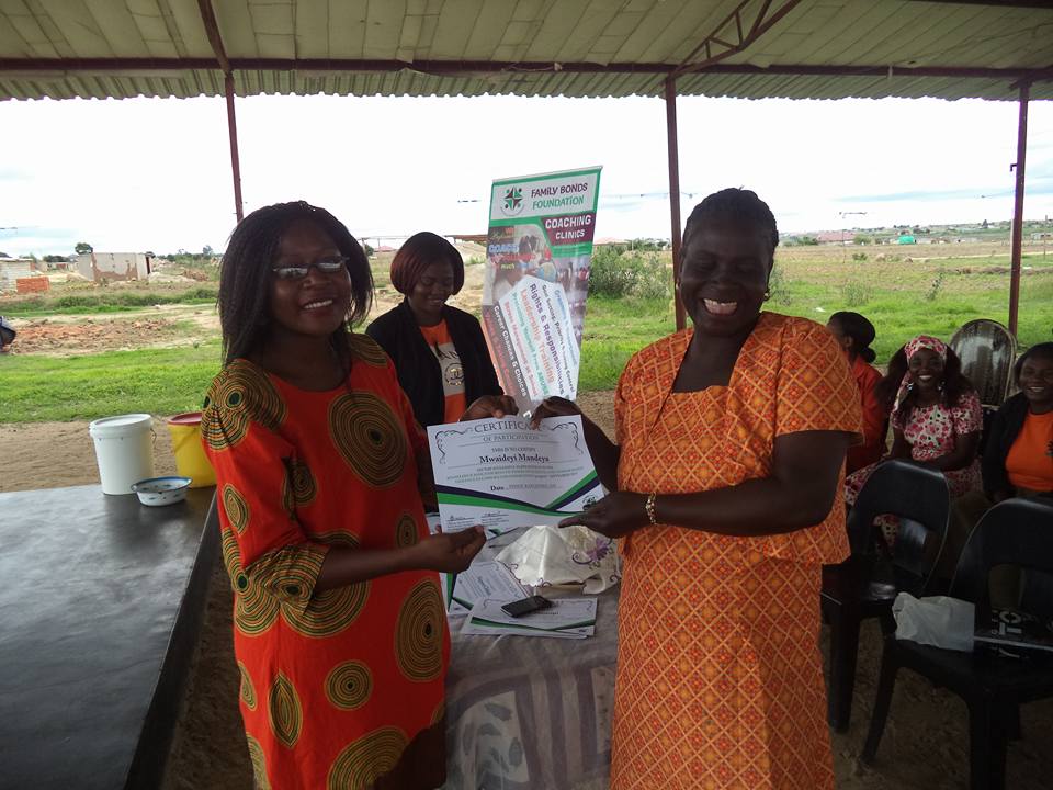 Me with one of the participants of the Knowledge Base: Ensuring Victories Over Sexual and Gender Based Violence in Families and Communities with her certificate of participation.