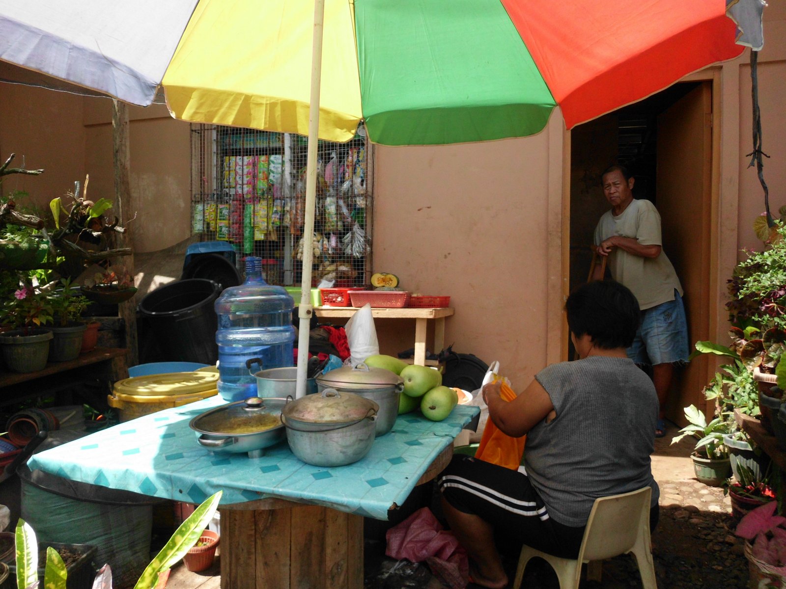 The front yard at the Ecoville Resettlement becomes a breakfast nook where residents can buy ready-made meals. Photo by libudsuroy.CreativeCommons