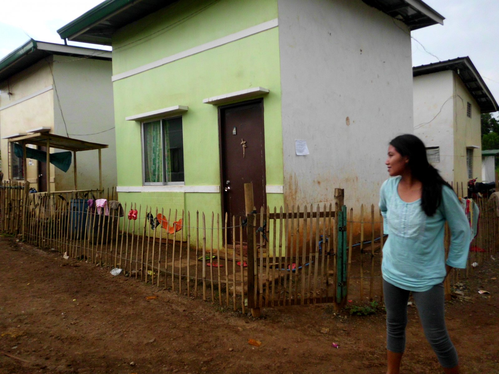 A houseowner stands by her own home at St. Augustine Village. Photo by libudsuroy. CreativeCommons