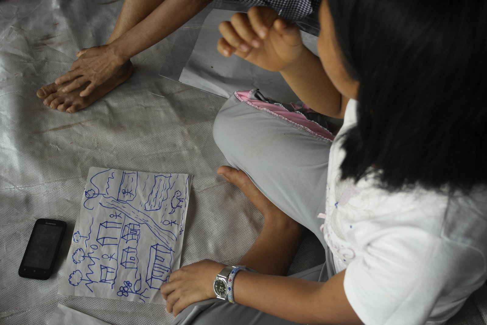 A participant sketches the terrains of her village as she envisions it to be. Photo by libudsuroy