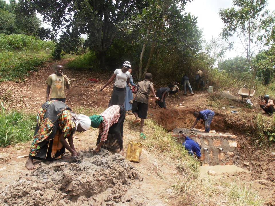 Women helping out at a construction of spring well in Uganda